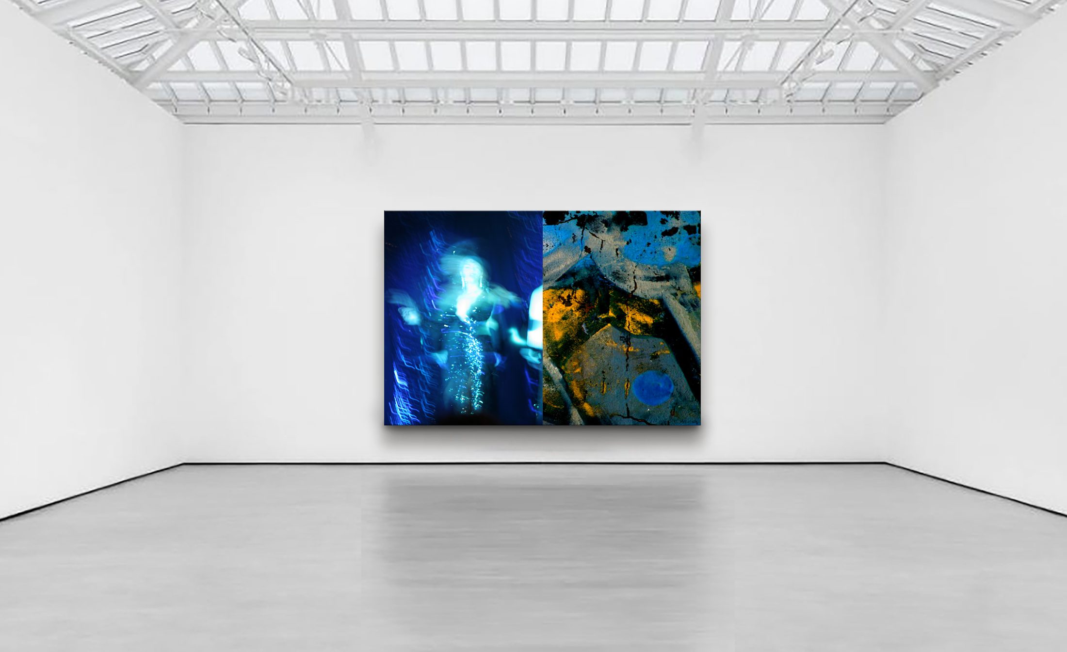 Fine art photography by Kevin Kay: a large diptych hanging in a white, skylit gallery — a blue, motion-blurred figure beside an abstract field of blue and ochre.